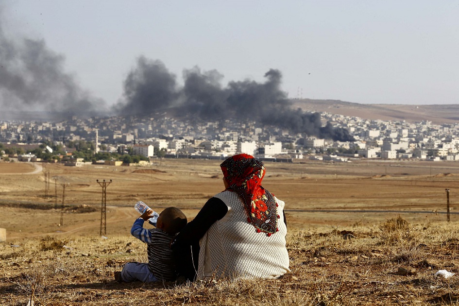 Turkish Kurds watch smoke rises over Syrian town of Kobani after an airstrike, as seen from the Mursitpinar border crossing on the Turkish-Syrian border in the southeastern town of Suruc in Sanliurfa province, October 18, 2014 (Reuters)