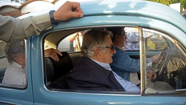 Jose Mujica arrives on his Volkswagen accompanied by his wife. (Photo: Reuters)
