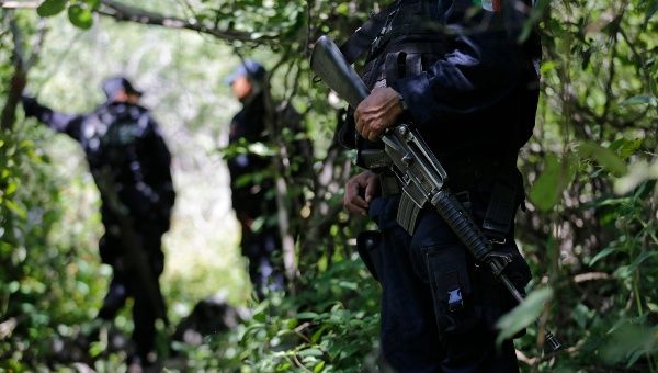 Iguala police agents patrol the area where secret graves were found in Pueblo Viejo, outside of Iguala, in the southern Mexican state of Guerrero. October 9, 2014. Mexican authorities said that four of the graves contained charred remains which could belong to the group of 43 students that went missing in Iguala on September 26, 2014. (Photo: Reuters/Henry Romero)