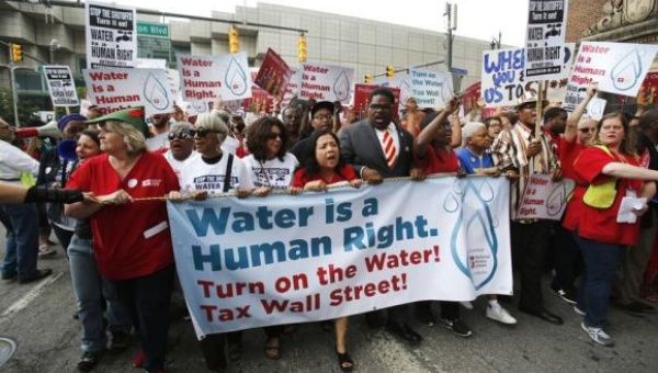 People hold a banner against the mass water shut-offs to Detroit citizens behind in their payments, during a protest in downtown Detroit, Michigan July 18, 2014. (Photo: Reuters)