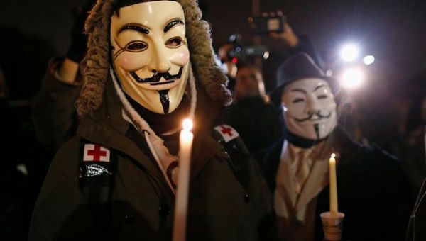 Protesters wearing Guy Fawkes masks take part in a candlelight vigil outside the Ferguson Police Department (Photo: Reuters)