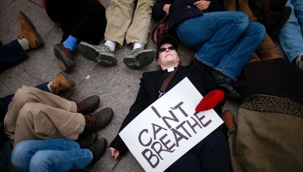 A protester, demanding justice for Eric Garner, holds a placard while staging a protest against the killing of Eric Garner.