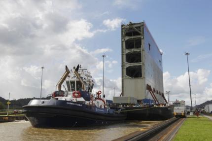 Tugboats help a barge transporting the last rolling gate for the new locks on the Pacific side of the Panama Canal through the Miraflores locks in Panama City December 10, 2014.