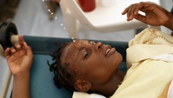 A Haitian girl with cholera symptoms is doused with water at an improvised clinic run by Doctors Without Borders in Port-au-Prince