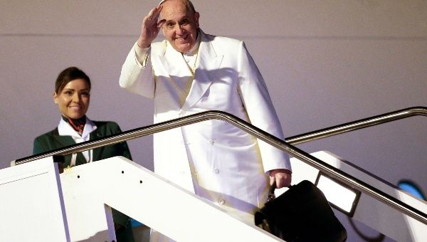 Pope Francis waves as he boards a plane for his trip to Sri Lanka and the Philippines at Fiumicino airport in Rome January 12, 2015