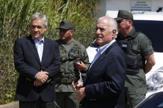 Former Presidents Sebastian Pinera of Chile (L) and Andres Pastrana of Colombia, are stopped by national guard soldiers outside the military prison of Ramo Verde on the outskirts of Caracas Jan. 25, 2015.
