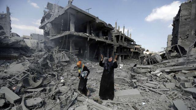 A Palestinian woman pauses amid destroyed buildings in the northern district of Beit Hanun in the Gaza Strip after massive, indiscriminate attacks by Israel on July 26, 2014.