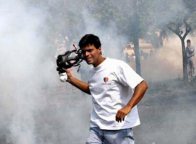 Lopez, gas mask in hand, participating in the coup against Chavez while wearing a shirt of the municipality he was mayor of