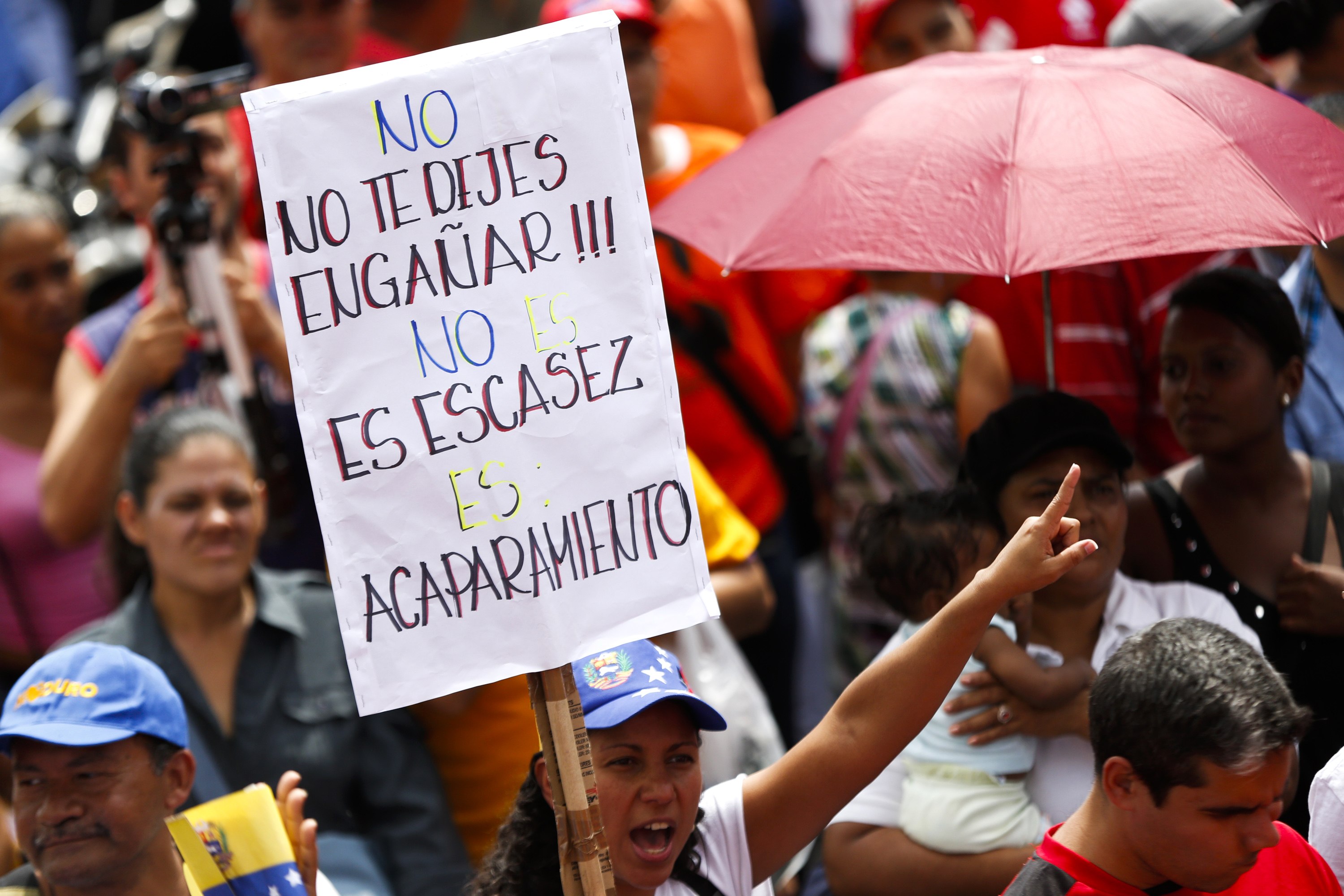 A pro-Venezuelan government protester holds up a banner that reads, 