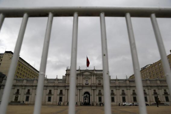The La Moneda presidential palace is seen through a security barrier in Santiago, Chile.