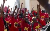 Members of the National Union of Metal Workers of South Africa (NUMSA) point at workers at a construction site not taking part in the strike during a protest on the streets of Durban
