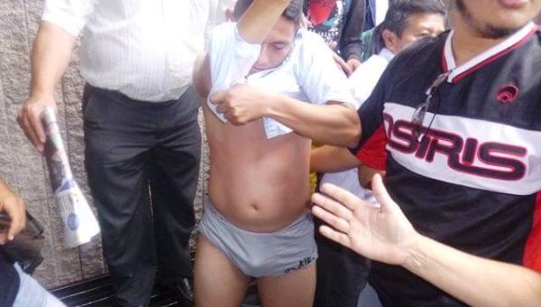 A undercover police agent was discovered and the protesters took his cloths looking for weapons of recording devices.