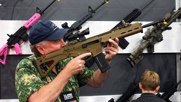 A man with an assault rifle at an exhibit booth at the George R. Brown convention center, the site for the 2013 National Rifle Association's annual meeting.