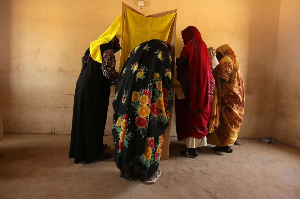 Sudanese women prepare to cast their votes at a polling station in a suburb of Khartoum, April 14, 2015, on the second day of voting of national elections.