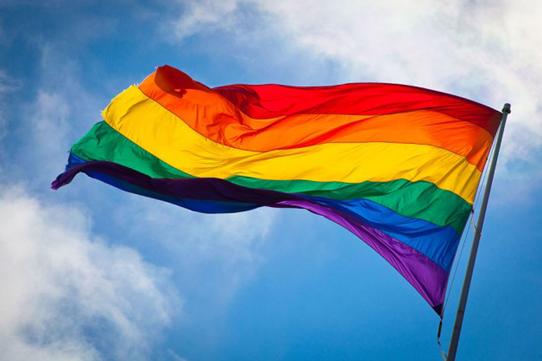 Rainbow flag waving during a gay pride parade.