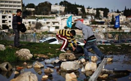 Palestinian children collect water in the Sheikh Jarrah neighbourhood in East Jerusalem