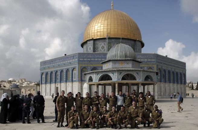 Israeli soldiers pose for a photo in front of the Dome of the Rock in the Al-Aqsa mosque compound.