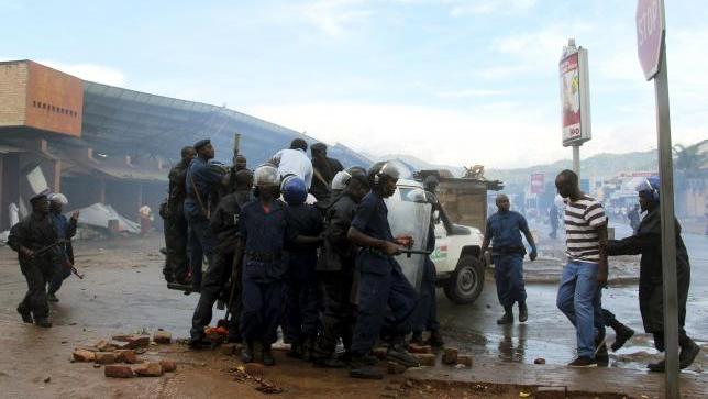Burundi policemen detain protesters opposing President Pierre Nkurunziza from running for a third term, in the capital Bujumbura, April 17, 2015.