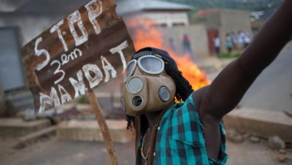 A protester in the Burundian capital of Bujumbura on Wednesday holds a sign that reads ‘Stop the third mandate’ of president Pierre Nkurunziza. 