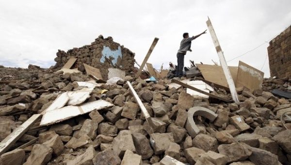 A young Yemeni man searches through a pile of rubble of a house destroyed by Saudi airstrikes, in Sanaa, the capital city of Yemen.