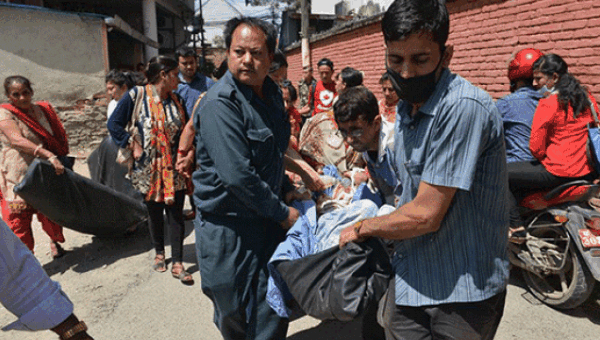 Locals carry an earthquake victim in Nepal after a second major quake hit the country May 12. Healthcare services have been completely overwhelmed in the country from the high number of injuries.   