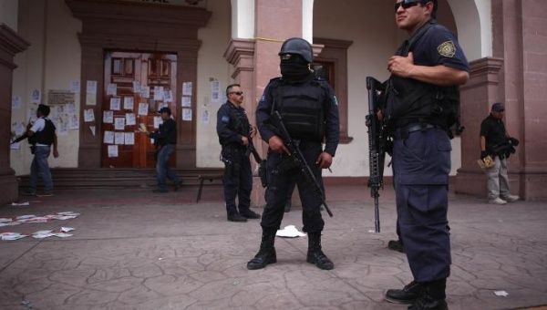 Police guard outside the town hall after a shooting between federal forces and armed civilians in the town of Apatzingan, Michoacan Jan. 6, 2015.