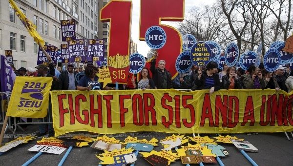 Demonstrators hold signs during demonstrations asking for higher wages in the Manhattan borough of New York April 15, 2015