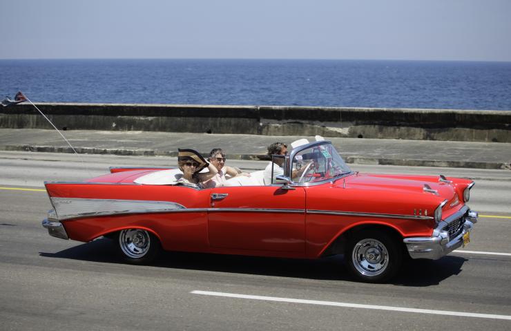 U.S. tourists ride a 1957 Chevrolet Bel-Air convertible on Havana's seafront boulevard, El Malecon, May 21, 2013,.