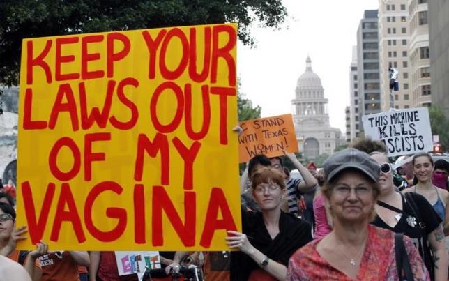 Women's rights activists carry signs during an abortion rights march in Austin, Texas, July 8, 2013.