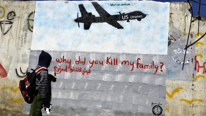 A child looks at a drone graffiti in a street or Sanaa, Yemen.