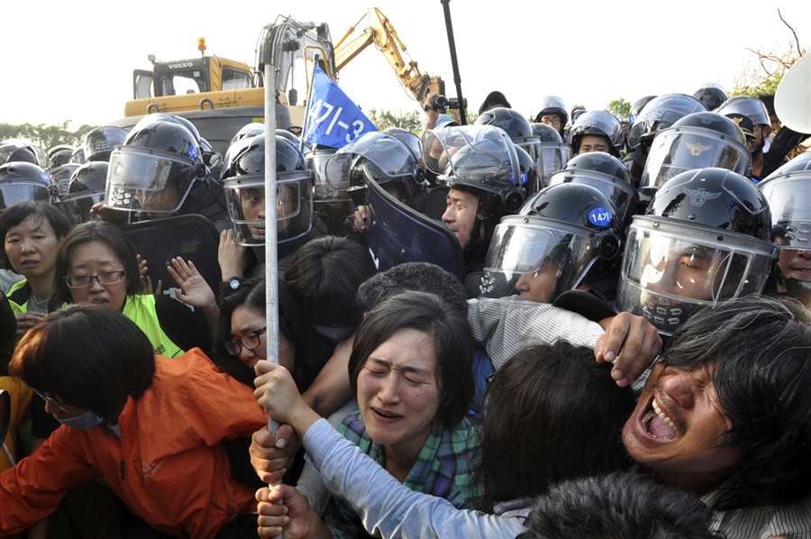 Riot police struggle with protesters during a rally against the construction of a new naval base in Seogwipo on Jeju island September 2, 2011.