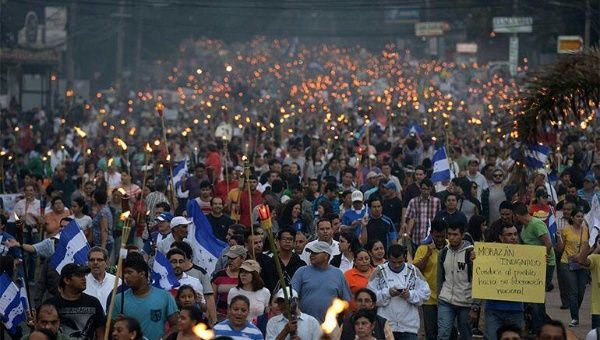 Thousands of Houndurans marched in the streets of Tegucigualpa carrying torches to protest corruption and demand that President Juan Orlando Hernandez resign.