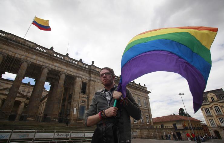 A man holding a rainbow flag during a protest demanding rights for the LGBT community outside the Congress building in Bogota, Nov. 27, 2012.