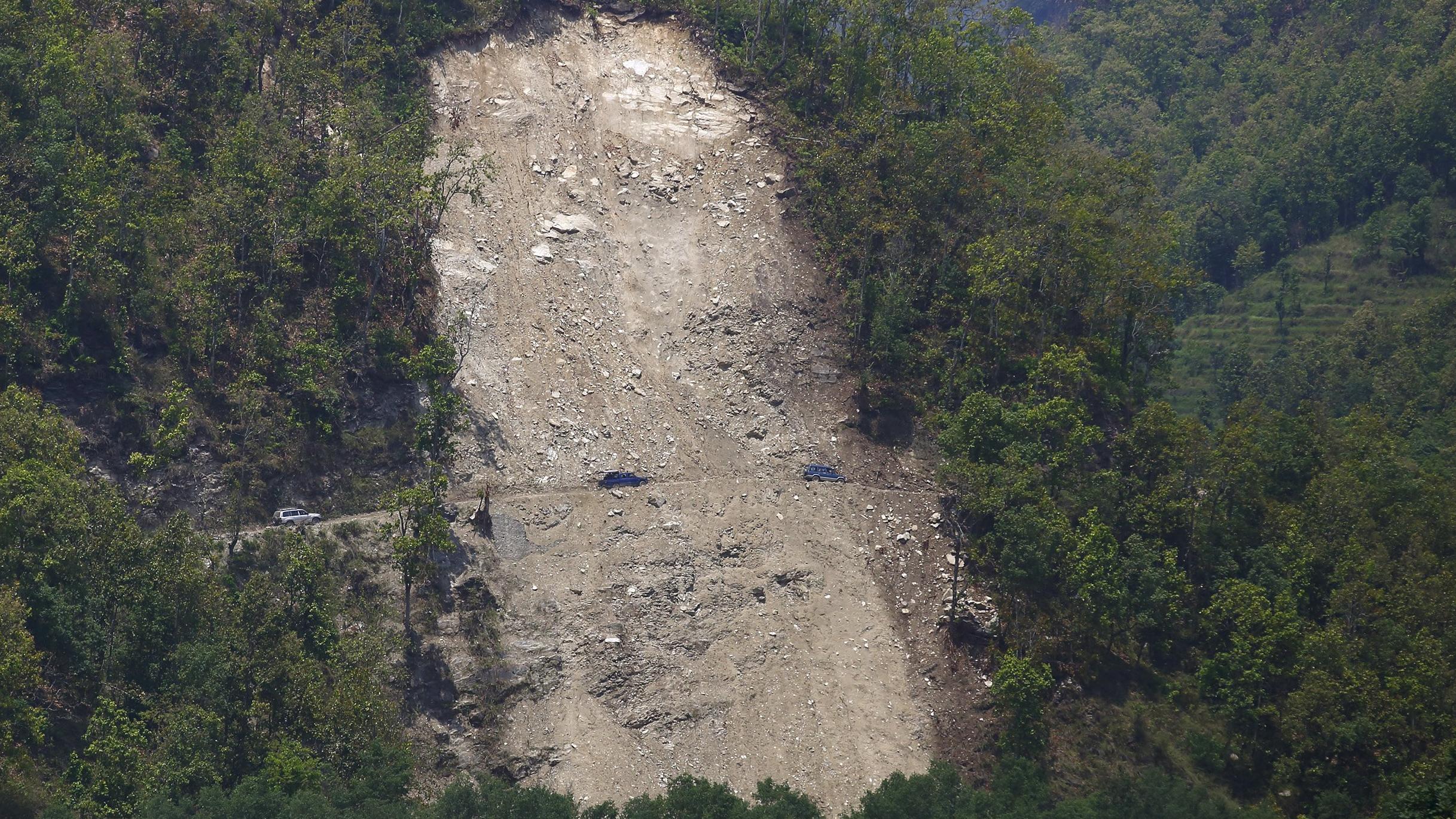Vehicles pass by a landslide area after the earthquake in Gorkha district May 20, 2015.
