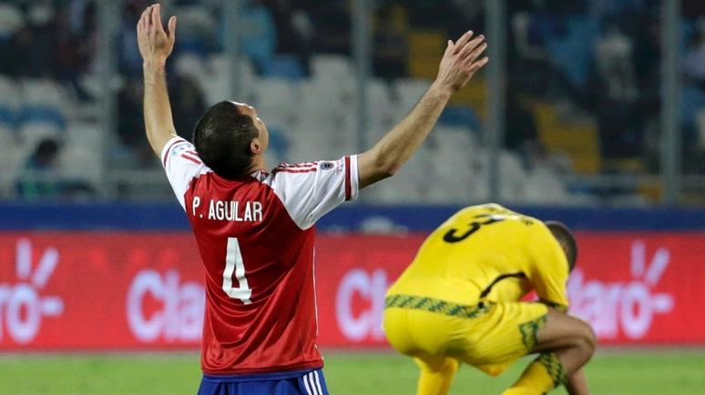 Paraguay's Pablo Aguilar celebrates as Jamaica's Michael Hector reacts after Paraguay won their first round Copa America 2015 soccer match, 1-0.