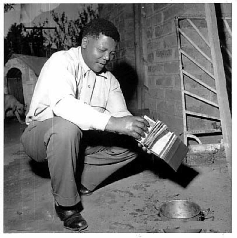 Nelson Mandela burns his passbook in 1952 in protest of the racist law that required Black South Africans to carry passbooks identifying their race and where they lived. Passbook carriers were prohibited from traveling to other parts of the country without their passbook.  