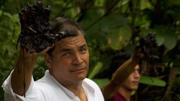 Ecuadorean President Rafael Correa holds up his oil-covered hand as proof of contamination in the amazon.