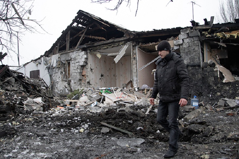 A man walks near a damaged residential building in Donetsk, eastern Ukraine January 19, 2015.