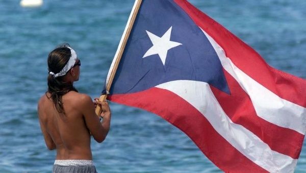 A man waves the flag of Puerto Rico