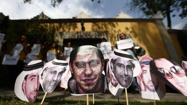 A picture of Saudi blogger Raif Badawi (C) is seen between others photos of prisoners in Saudi Arabia during a demonstration for his release from jail outside the Embassy of Saudi Arabia in Mexico City, February 20, 2015.