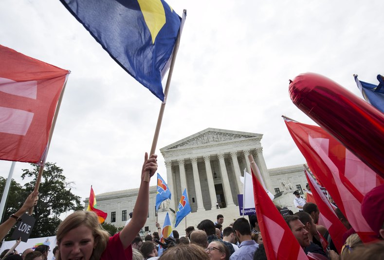 Supporters of gay marriage wave the rainbow flag after the U.S. Supreme Court ruled on Friday that the U.S. Constitution provides same-sex couples the right to marry at the Supreme Court in Washington June 26, 2015. The court ruled 5-4 that the Constitution's guarantees of due process and equal protection under the law mean that states cannot ban same-sex marriages. With the ruling, gay marriage will become legal in all 50 states.