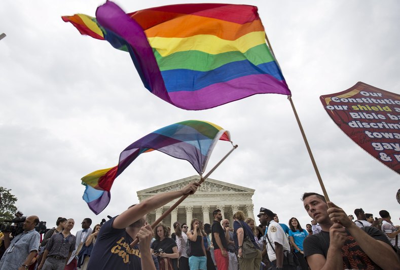 Supporters of gay marriage wave the rainbow flag after the U.S. Supreme Court ruled on Friday that the U.S. Constitution provides same-sex couples the right to marry at the Supreme Court in Washington June 26, 2015.