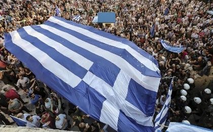 Protesters carry a gigantic Greek flag during a rally in front of the parliament building calling on the government to clinch a deal with its international creditors.