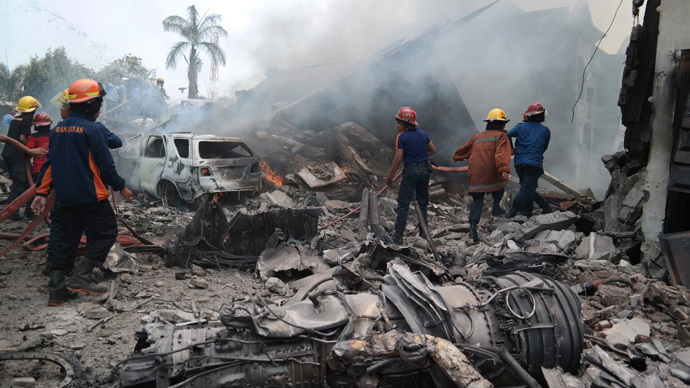 Firemen attempt to extinguish the fire surrounding the wreckage of an Indonesian military transport plane after it crashed in the city of Medan, Indonesia, June 30, 2015.