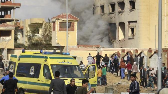 Egyptian residents and emergency personnel gather at the site of a car bomb explosion that targeted a police station in North Sinai's provincial capital of El-Arish on April 12, 2015.