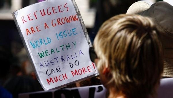 Protesters hold placards condemning Australia's refugee policies at a rally in support of asylum-seekers in Sydney.