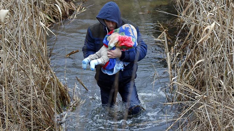 A Kosovar man carries his baby as he crosses the Hungarian-Serbian border without documents, near the village of Asotthalom, Feb. 6, 2015.