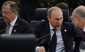 Russian Foreign Minister Sergey Lavrov (L) sits behind President Vladimir Putin (C) during the 2014 BRICS summit in Fortaleza, Brazil.