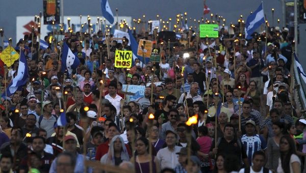 Honduran protesters take part in a torch-lit march to demand investigation into government corruption in Tegucigalpa July 3, 2015.