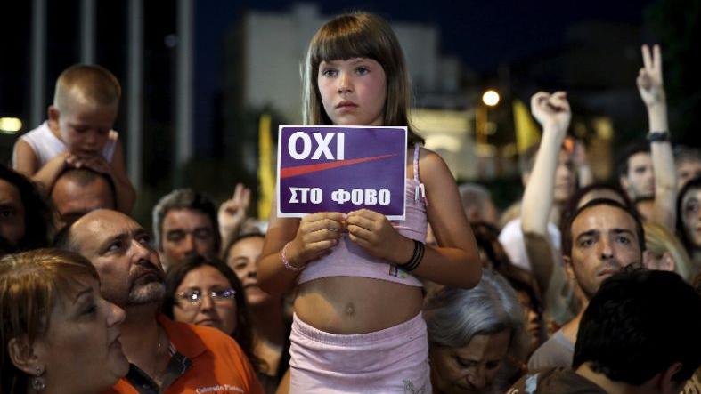 A girl holds up a sign that reads, 